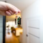 A hand holding a house-shaped keychain for the Arizona landlord tenant act