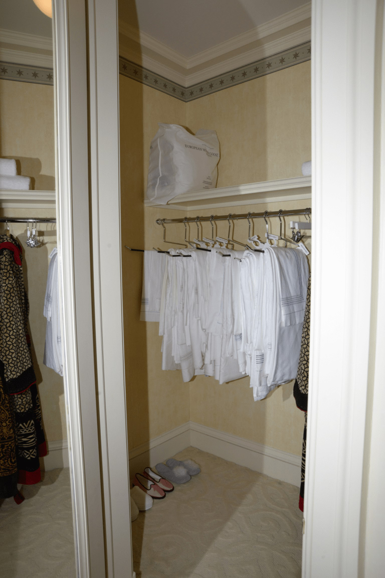 Neatly organized closet with clothes on racks