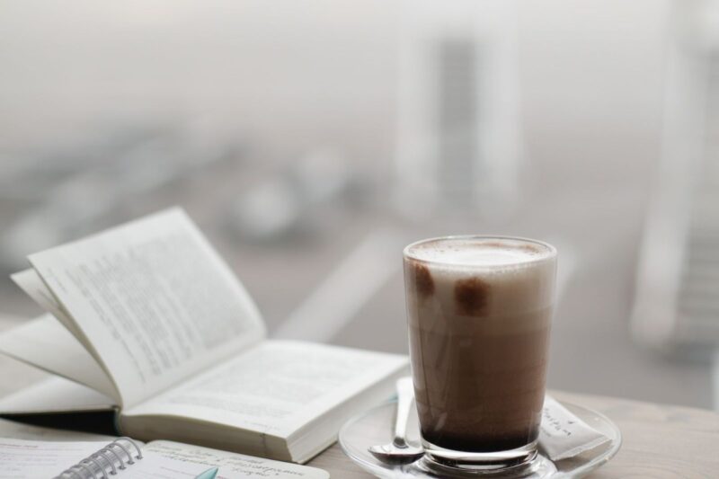 Warm coffee beside a notebook in morning light