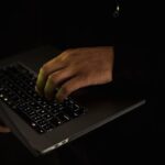 A person using a laptop in a dark room